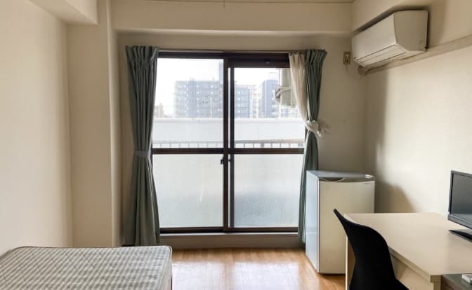 寝具、テレビ、エアコンが設置された個室内観の写真