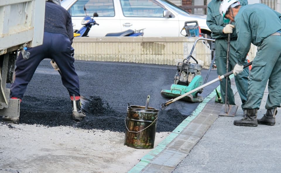 道路の舗装工事を行う作業員たち
